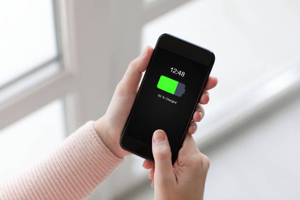 istock Women hands holding phone with charged battery on screen 672884716