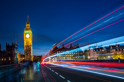 Big Ben at night and Westminster bridge with red and blue car light trails