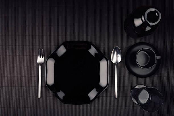 istock Dark modern minimalistic restaurant menu mock up  with black glossy plate, spoon, fork, cup, top view. 672891214