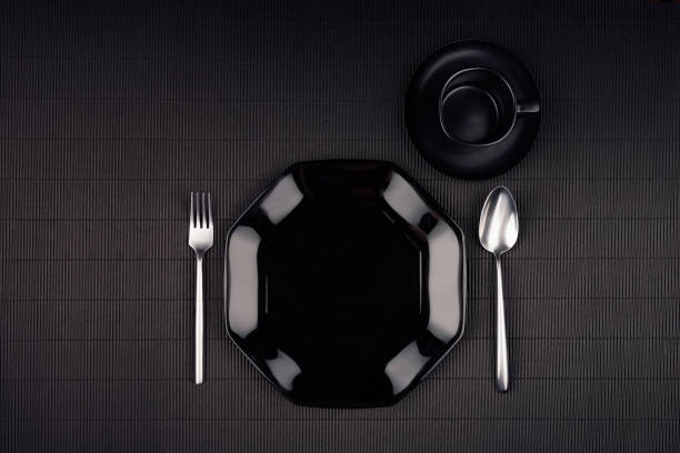 istock Dark modern minimalistic restaurant menu mock up  with black glossy plate, spoon, fork, cup, top view. 672891224