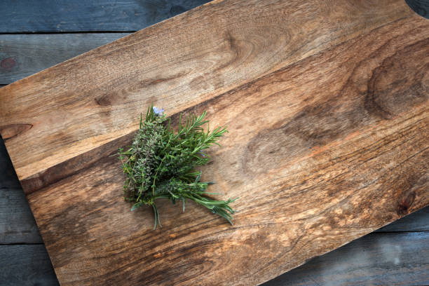 Fresh herbs on a cutting board Fresh rosemary and thyme herbs on a cutting board aromatisch stock pictures, royalty-free photos & images