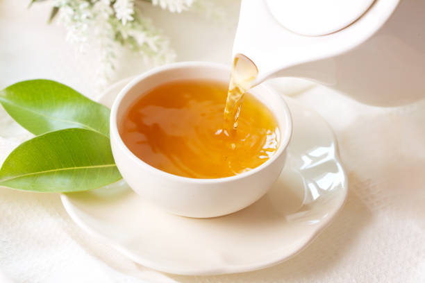 istock pouring hot black tea in a white tea cup 672909732