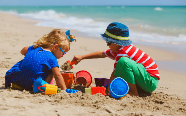 istock kids play with sand on summer beach 672909916