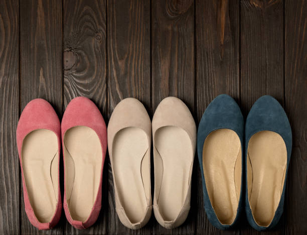 Women's shoes (ballerinas) pink, blue and beige on a dark wooden background. Women's shoes (ballerinas) pink, blue and beige on a dark wooden background. Selective focus. womens blue suede shoes stock pictures, royalty-free photos & images