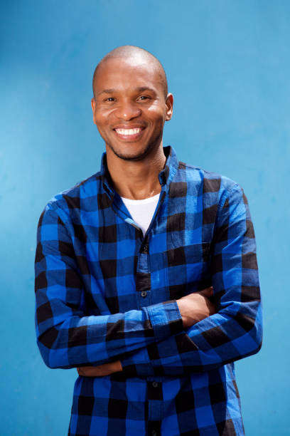 istock handsome young man smiling against blue background 672915148