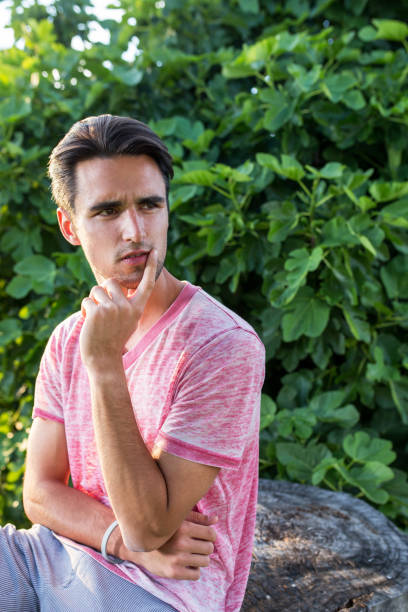 istock Young pensive man holding hand on chin. 672916154