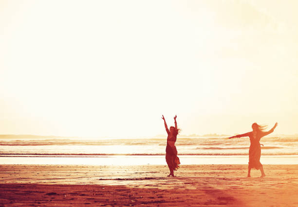 Shot of two young women spending the day at the beach at sunset