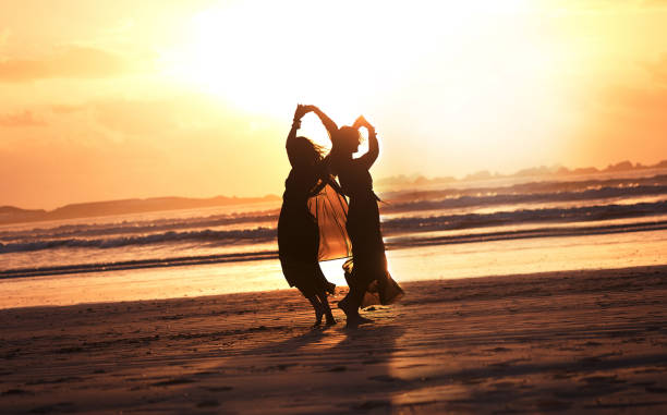 Shot of two young women spending the day at the beach at sunset