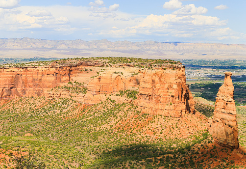 The rock formation Independence Monument and Monument Canyon as part of the Colorado National Monument. In the back the Book Cliffs.