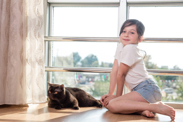 istock little girl is playing with her cat 672944224