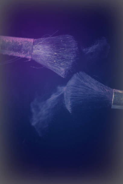 istock Make up brush with purple dust on black background 672944376