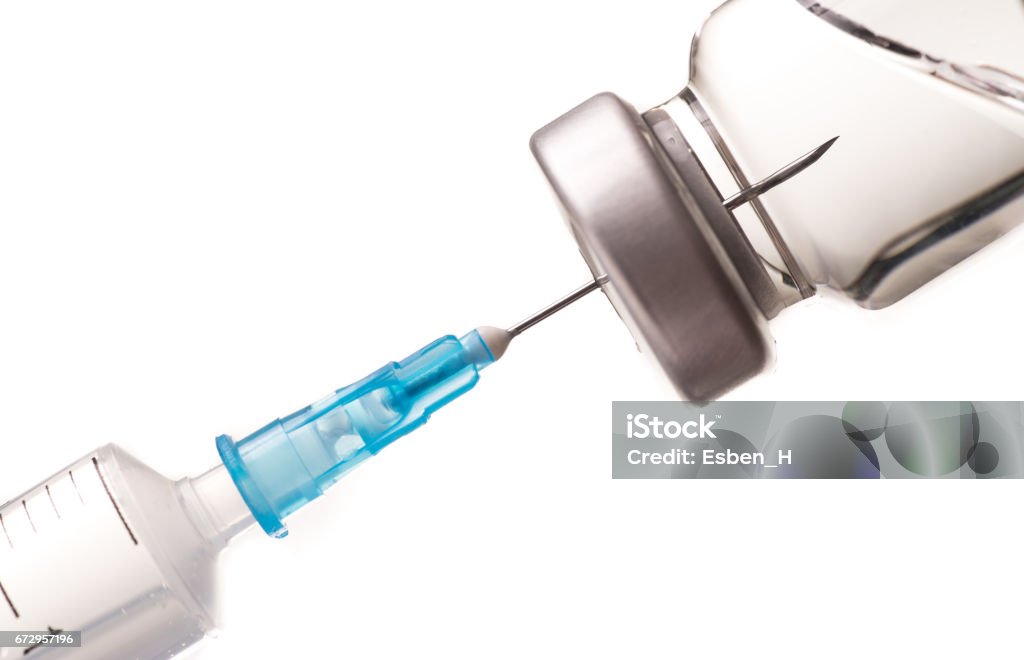 Syringe, needle and medicine vial. Syringe, needle and medicine vial. The needle sticks through the sterile membrane into the clear liquid. Syringe Stock Photo