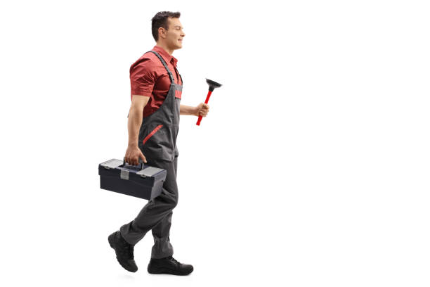 istock Plumber holding a plunger and a toolbox walking 672957950