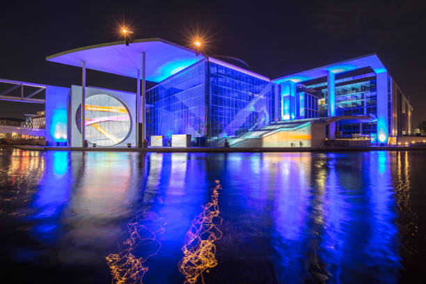 Panoramic view of modern Berlin government district with famous Spree river illuminated in beautiful post sunset twilight during blue hour at dusk in summer, central Berlin Mitte, Germany