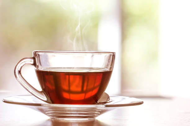 istock warm black tea cup on  wooden table in living room 672958384