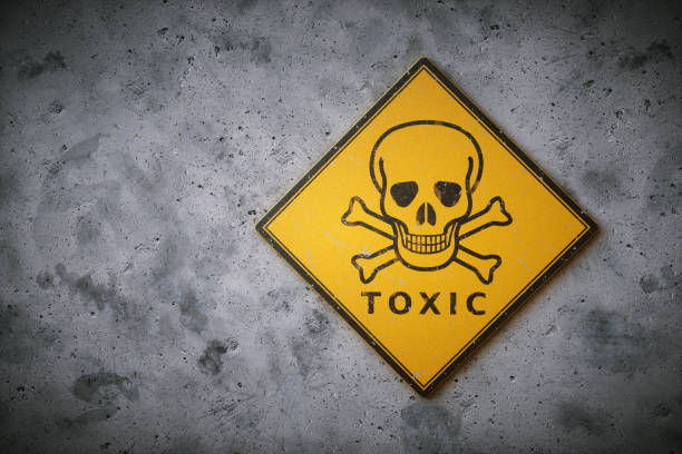 Skull & Crossbones Sign A square yelow sign with the international symbol for poison and other chemical / biological hazard. The sign is set on a dirty concrete wall surface. hazard sign photos stock pictures, royalty-free photos & images