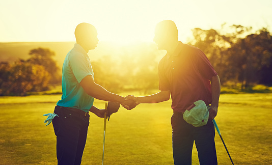 Shot of two golfers shaking hands on the golf course