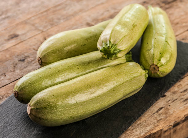 istock Fresh zucchini on wooden background 672968096