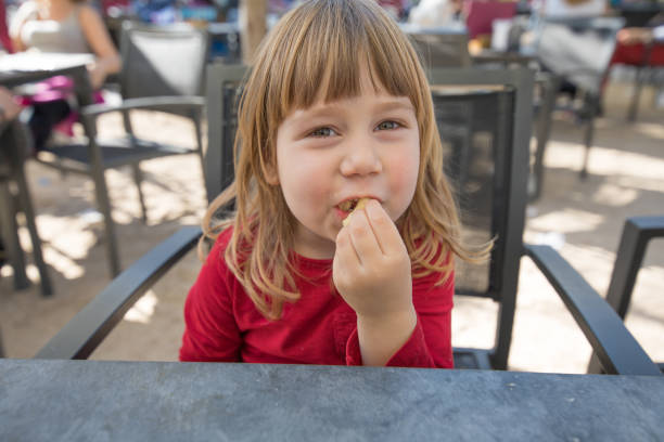 istock child in exterior bar eating cheese puff 672973304