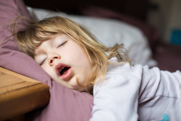 funny face of child sleeping on king bed stock photo