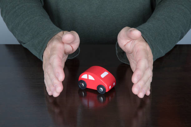 istock hands of man protecting a toy car 672973462
