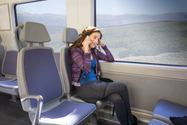 istock woman sitting in train talking on mobile 672973726