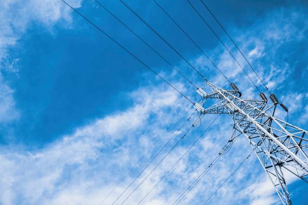istock High voltage power pylons against blue sky with cloud. 672989706