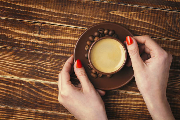 istock woman's hands holding a saucer with a cup of coffee 672995316