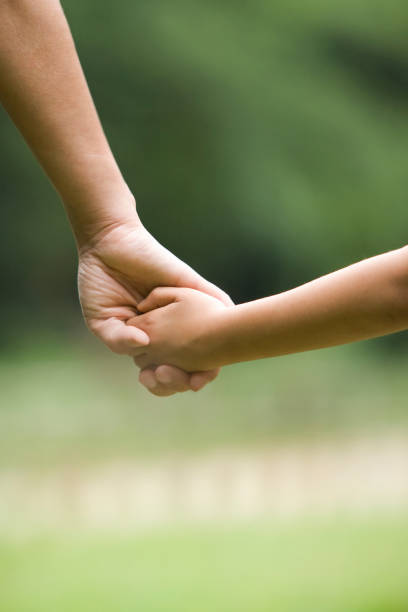istock Mother holding hands with children 672996936