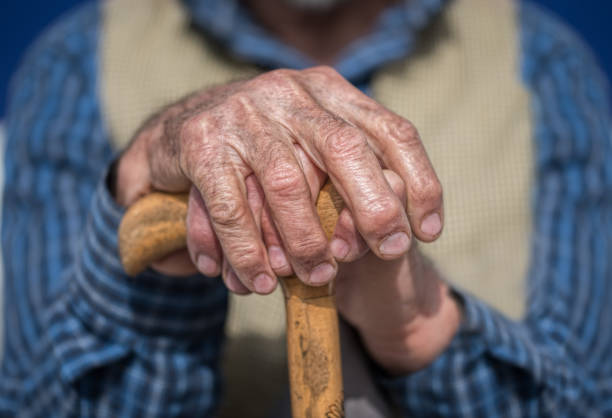 istock hands of a senior man on cane 672999920