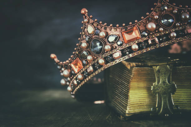 image clée bas de belle reine/roi couronne sur le vieux livre - couronne couvre chef photos et images de collection