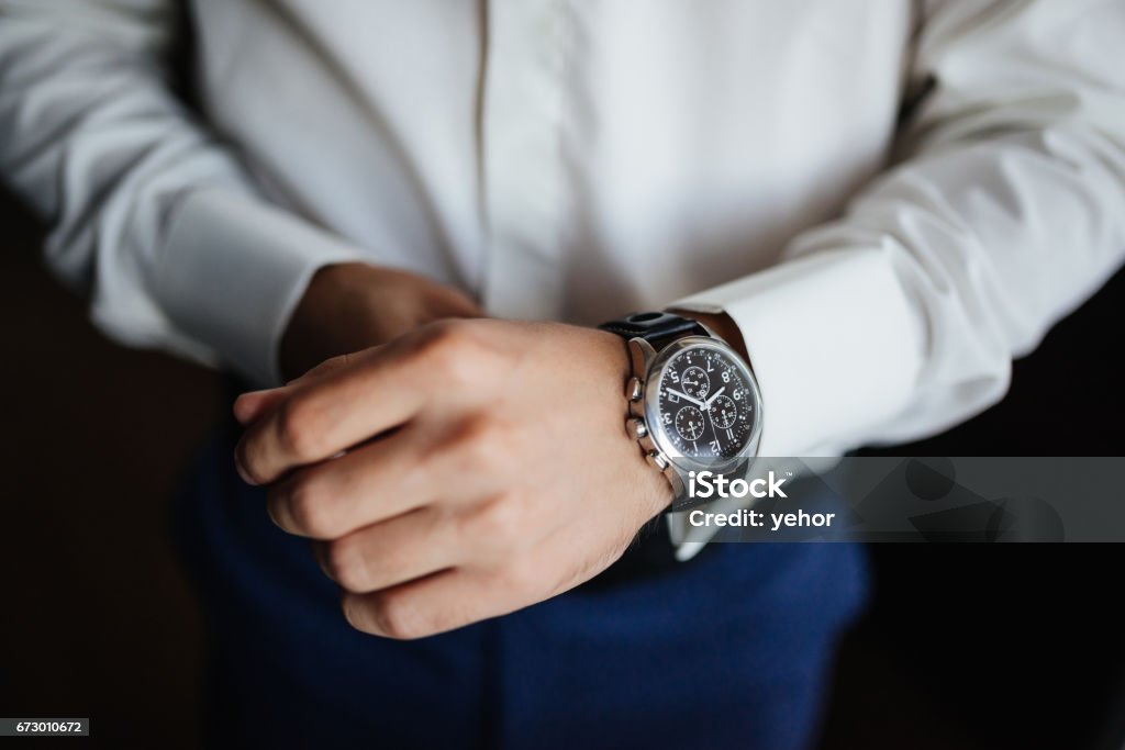 Préparation de la répétition. Du marié montres sur place. Vue d’angle élevé de groom, fixant ses montres avant mariage. - Photo de Hommes libre de droits
