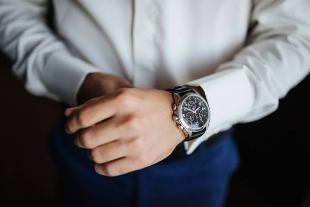 preparazione delle prove. orologi dello sposo a portata di mano. vista ad alto angolo dello sposo, fissando i suoi orologi prima del matrimonio. - cuff link suit men wedding foto e immagini stock