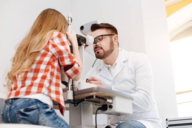 istock Concentrated diligent ophthalmologist observing patients eyes 673010746