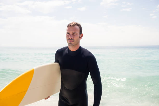 istock Surfer walking on the beach with a surfboard 673011940