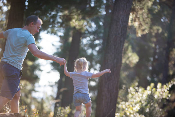 istock Father and daughter playing in the forest 673016886