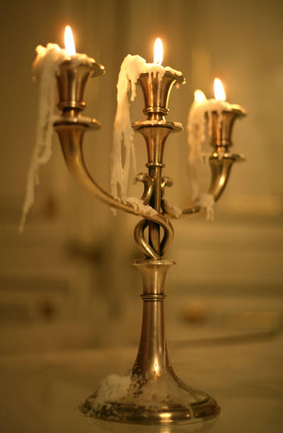 istock Three burning candles in an ancient gold candelabrum 673022098