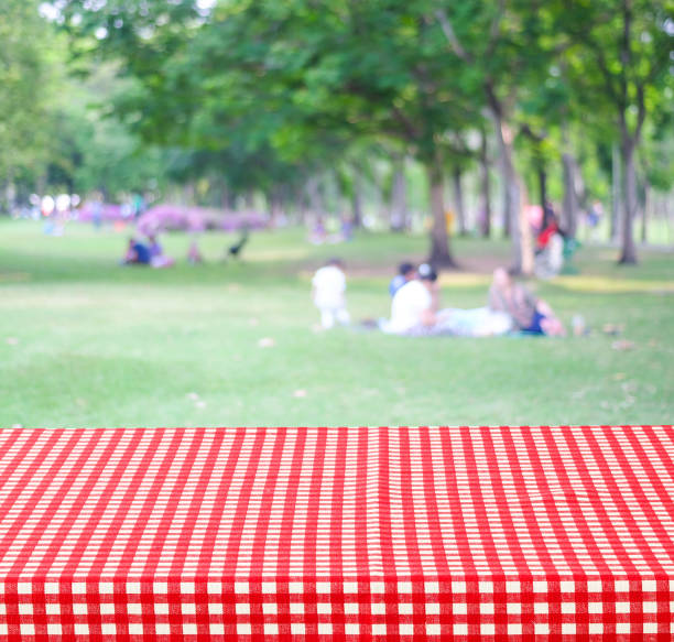 istock Empty table and red tablecloth over blur park with people background, for product display montage 673022120