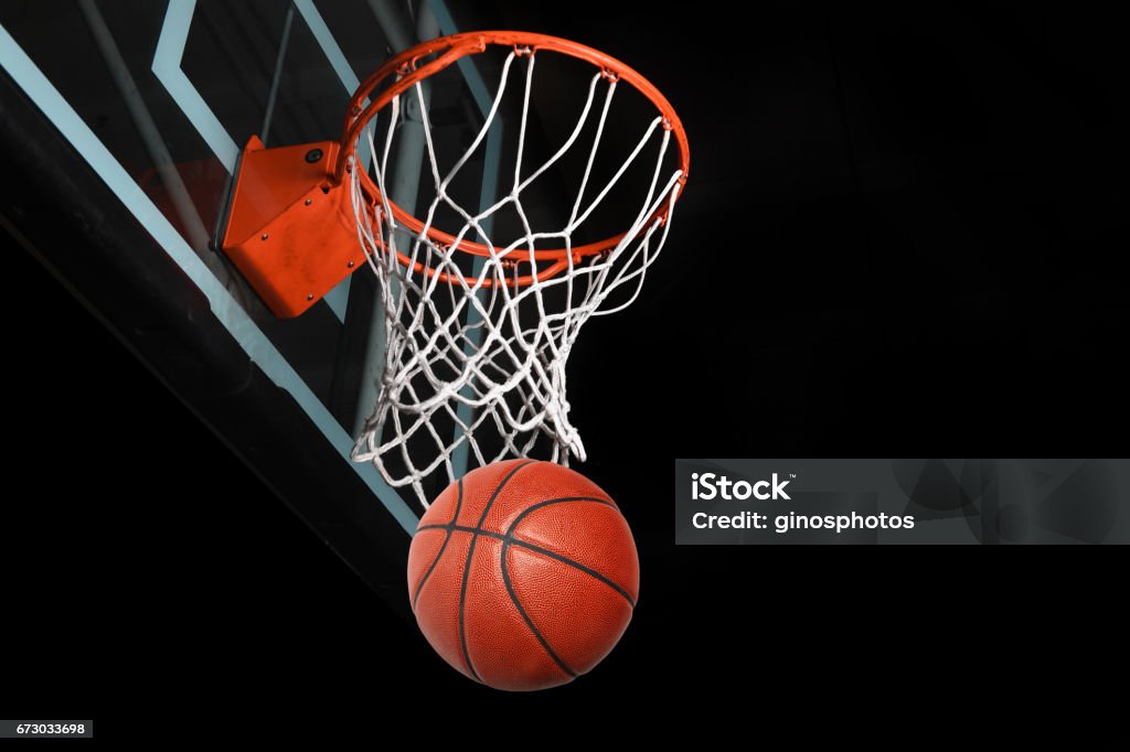 Basketaball Going Thorugh Hoop Basketball after going through hoop isolated over black background Basketball - Sport Stock Photo