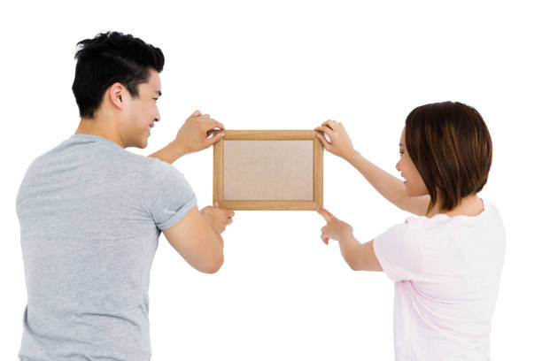 istock Young couple putting up picture frame 673034514