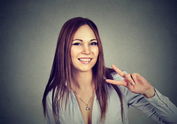 istock Young happy woman showing victory sign 673040146