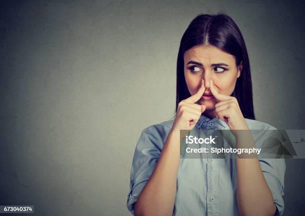 Woman Pinches Nose With Fingers Looks With Disgust Away Something Stinks Bad Smell Stock Photo - Download Image Now