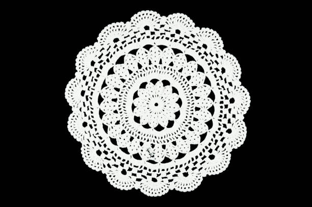 istock White hand made crocheted coaster on black background. Lace doily. 673053024