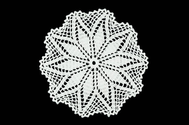 istock White hand made crocheted coaster on black background. Lace doily. 673055576