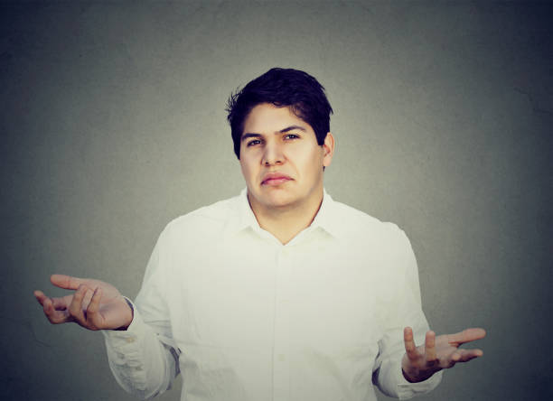 istock unsure confused man shrugging shoulders 673057218