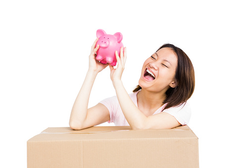 Happy woman holding a piggy bank on white background