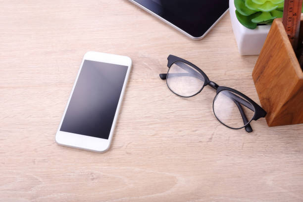 istock Blank screen smartphone and office supplies on wooden background 673074264