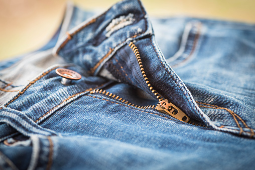 selective focus of blue jeans and gold zip