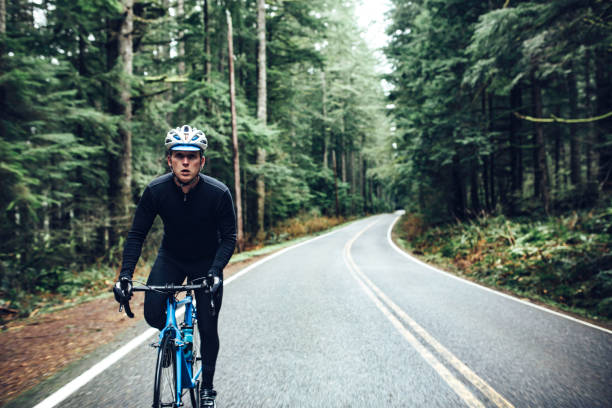 cyclist riding mountain road on racing bike - road cycling imagens e fotografias de stock