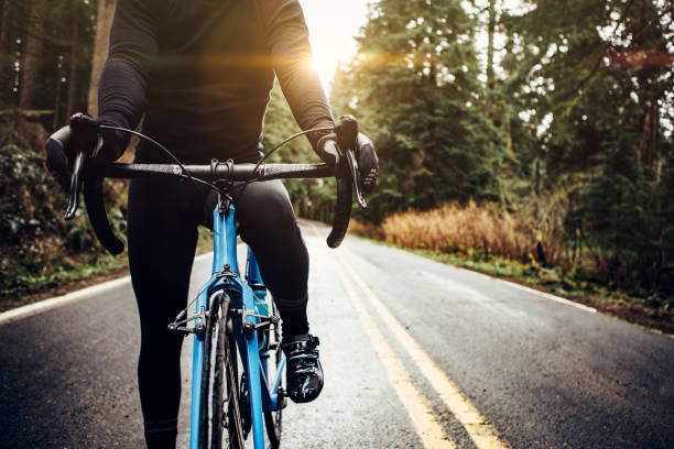 cyclist riding mountain road on racing bike - road cycling imagens e fotografias de stock